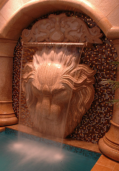 Giallo Fantasia Granite Lion Wall Fountain pouring into a pool with a weir.