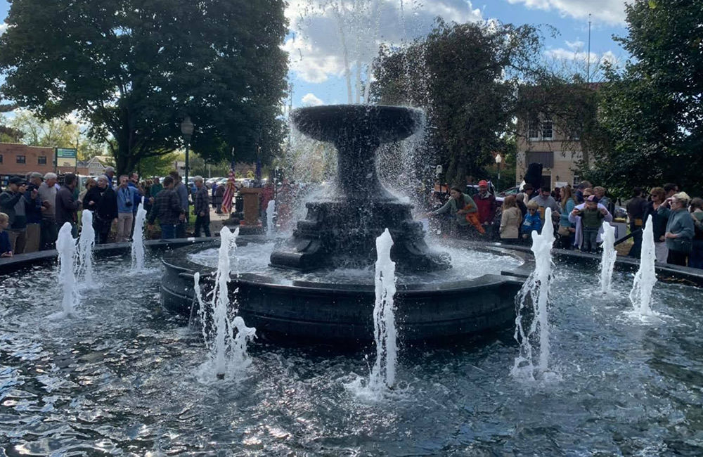 5 Ft x 6 Ft Tall urn fountain in a double pool surround installation (14 ft and 32.5 ft), carved of Steel Grey Granite. Located at Kellogg Park in Plymouth MI, this photo was taken during their grand opening event.