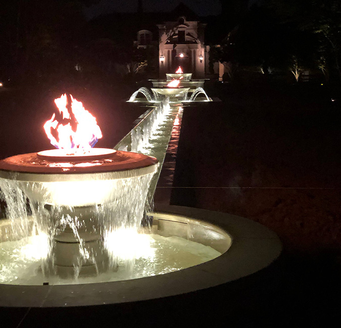 225 Ft Long x 26 Ft Wide Cascading Firebowl Fountain, which includes 3 firebowls of varying sizes, lots of bubbling nozzles, and (2) cascades. All stone items carved of Golden Cypress Granite.