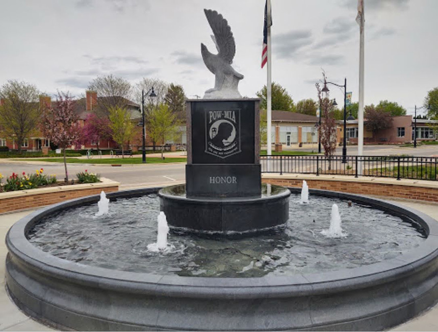 Verona WI Veterans Memorial Fountain, with a dual pool surround installation (7 ft diameter x 30 inch tall inner surround spilling water over into a 20 ft diameter x 18 inch tall outer surround.) All stone items carved of charcoal grey granite.