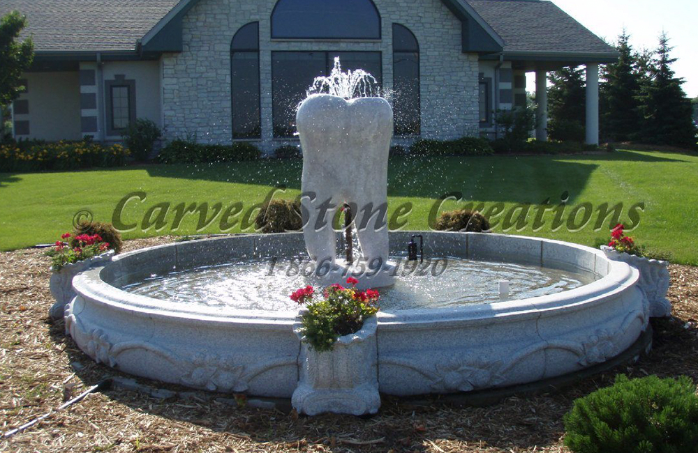 Custom Tooth Fountain with 12 Ft Diameter x 14 inch tall Cornucopia Pool Surround, carved of Bianco Catalina Granite, and displayed at a local dentists office.